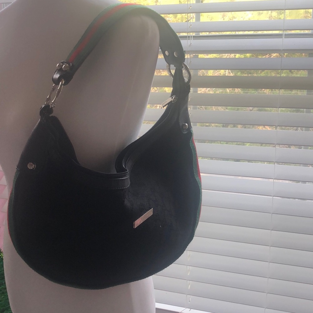 Black handbag with red and green strap